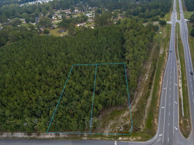 Aerial view from above W First Street Extension looking southeast, with both parcels outlined and GA Hwy 21 Bypass on the right